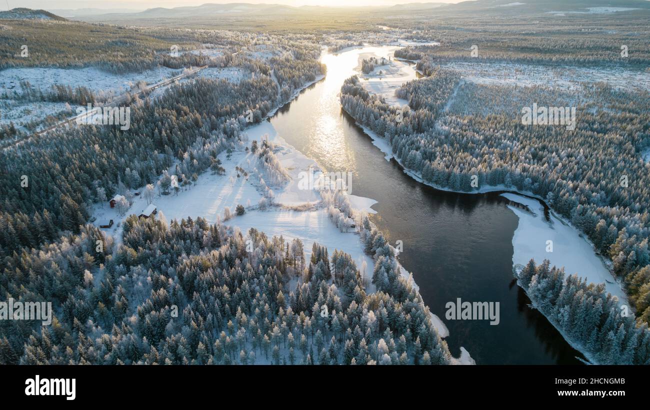 Aerial view of snowy winter forest with black river. Drone photography ...