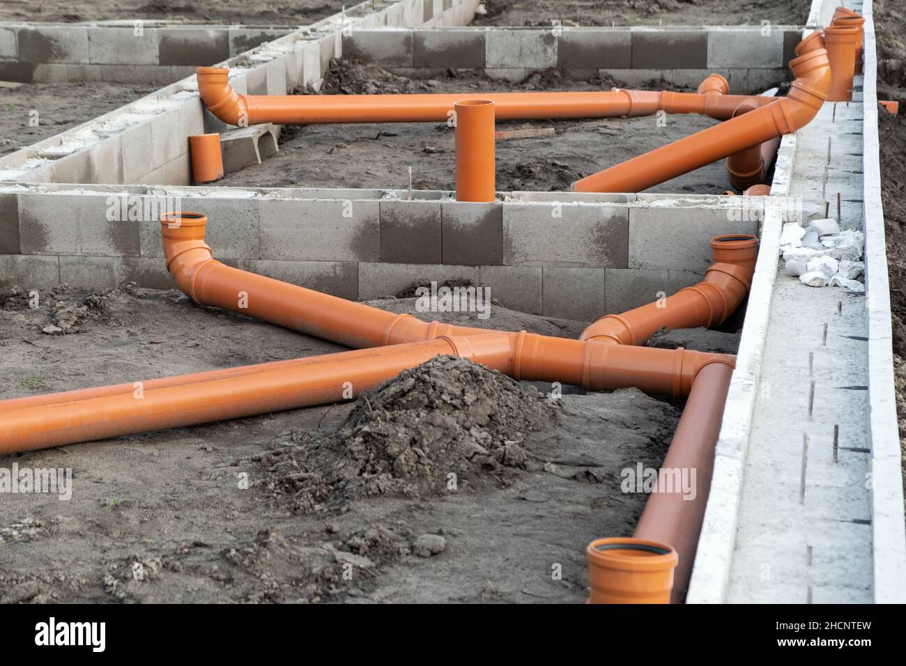 New Installed pipework system. Sewer Line developed and mounted on the  construction site. New Orange PVC plastic Drainage pipe Tube Stock Photo -  Alamy