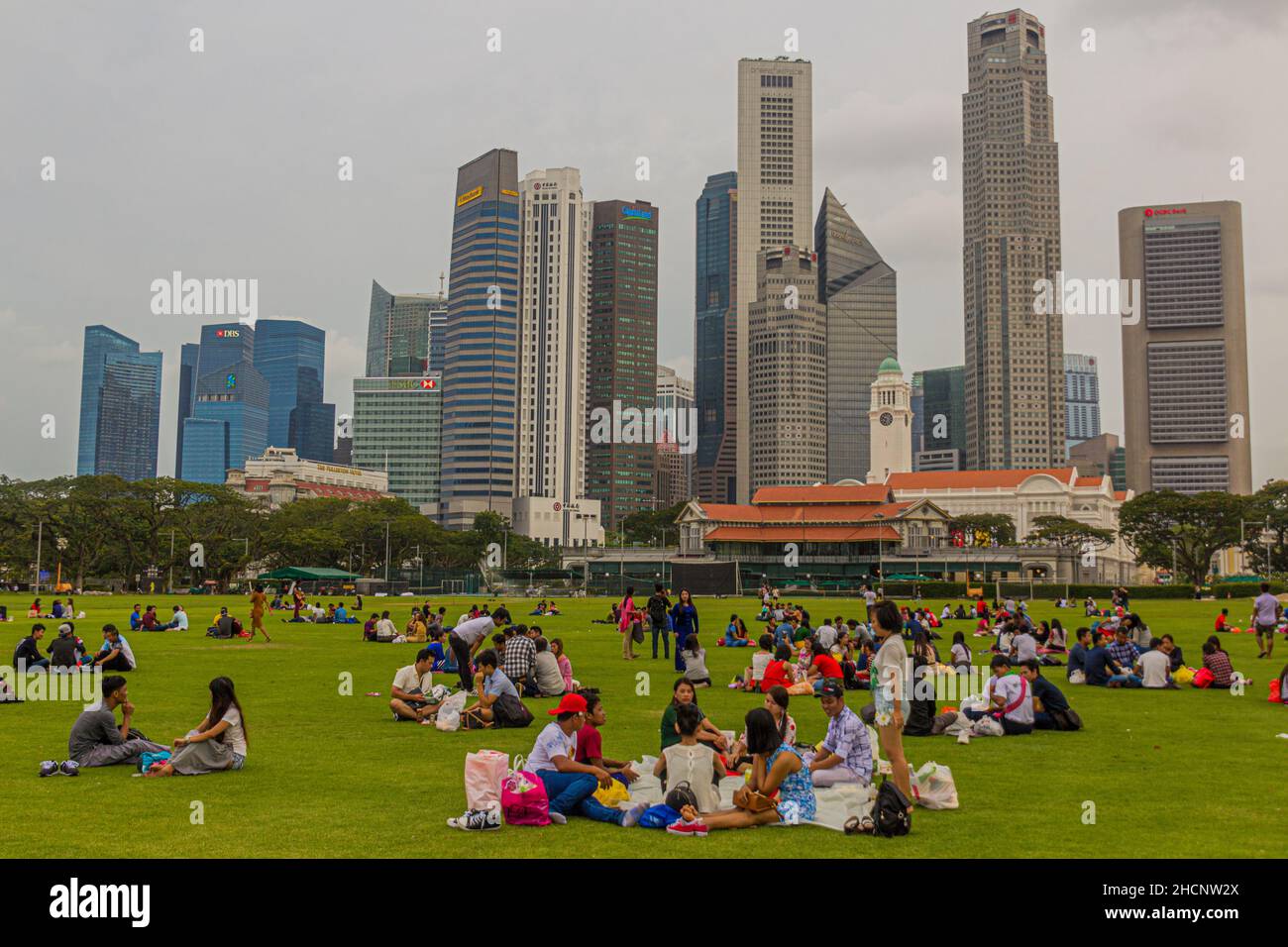 SINGAPORE, SINGAPORE - MARCH 11, 2018: People sit at the Padang ,open playing field in Singapore Stock Photo