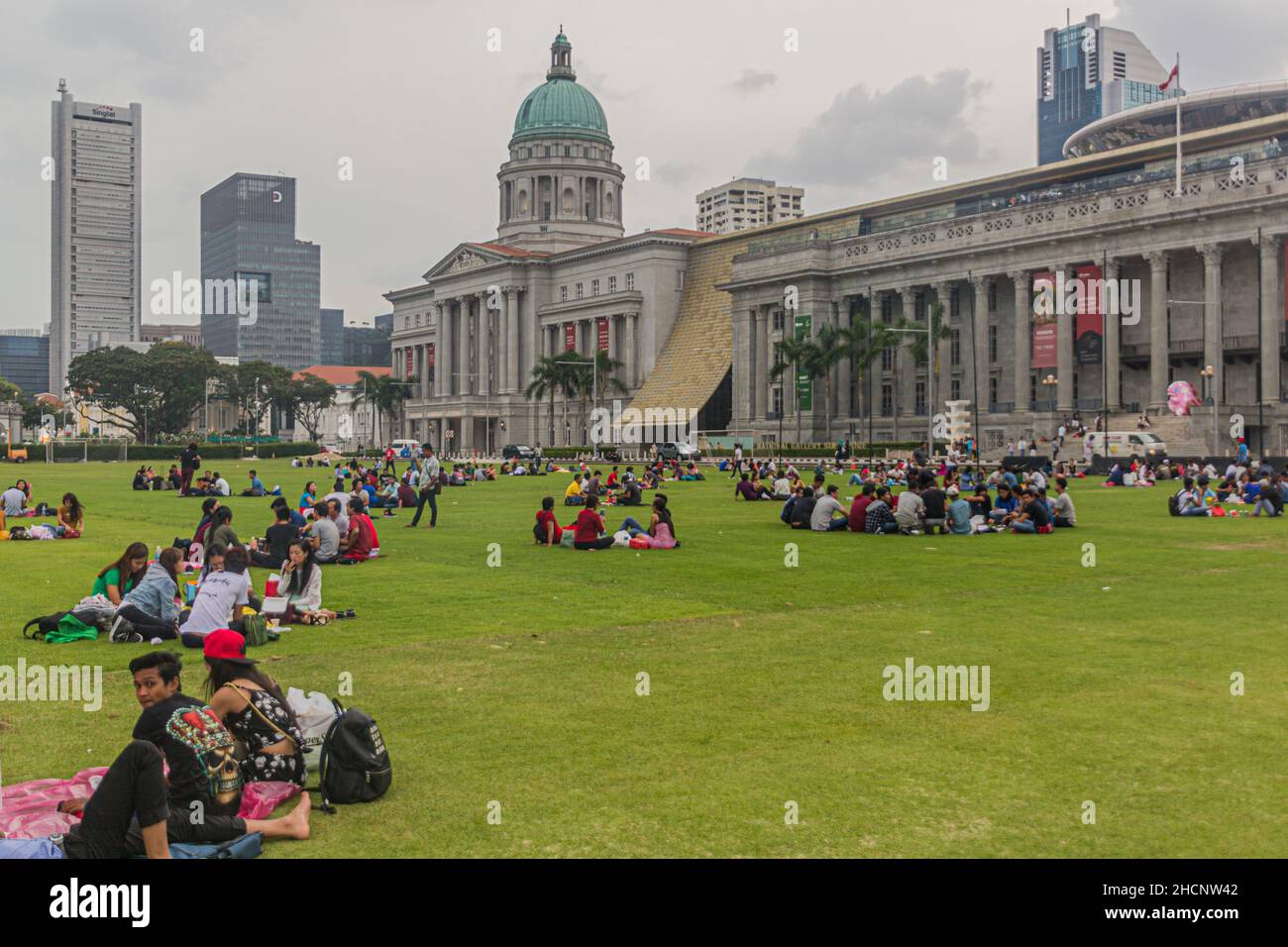 SINGAPORE, SINGAPORE - MARCH 11, 2018: People sit at the Padang ,open playing field in Singapore Stock Photo