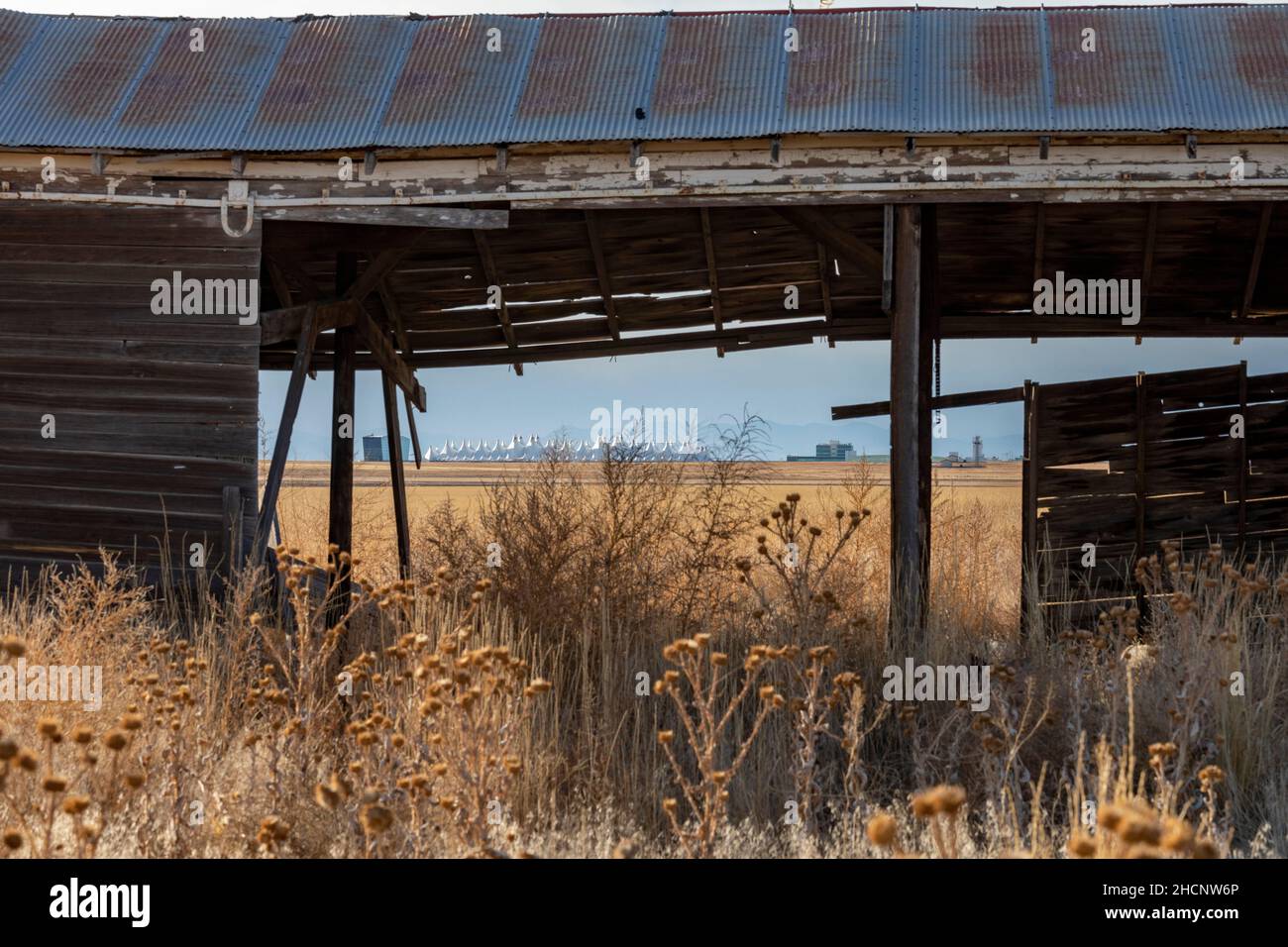 Denver, Colorado - The passenger terminal of Denver International Airport, viewed through an abandoned shed on the prairie east of the airport. Stock Photo