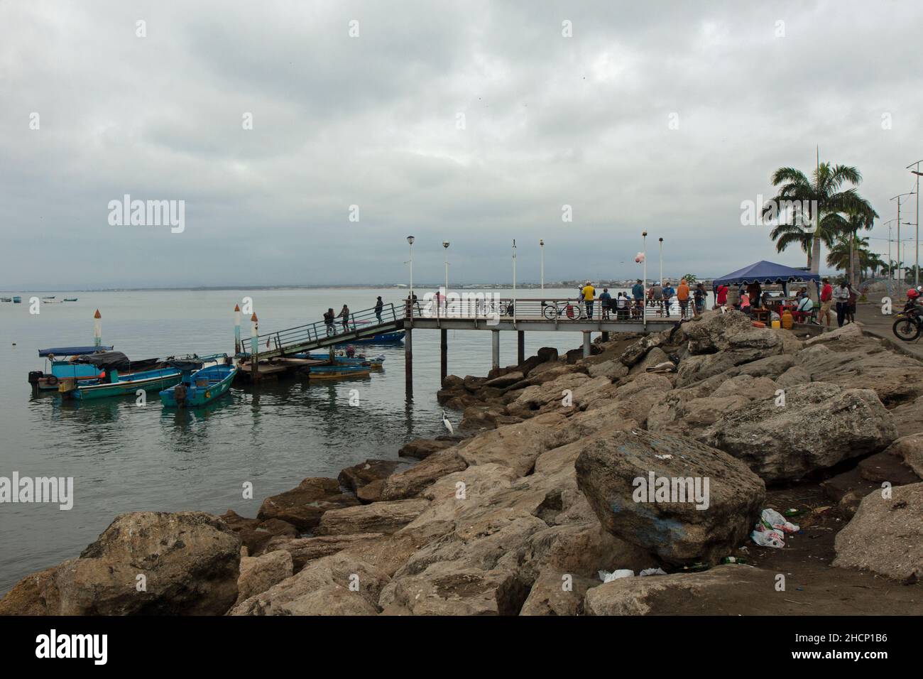 Manta, Manabi, Ecuador - December 19 2021: Fishermen resting on a pier in the city of Manta on a cloudy day Stock Photo