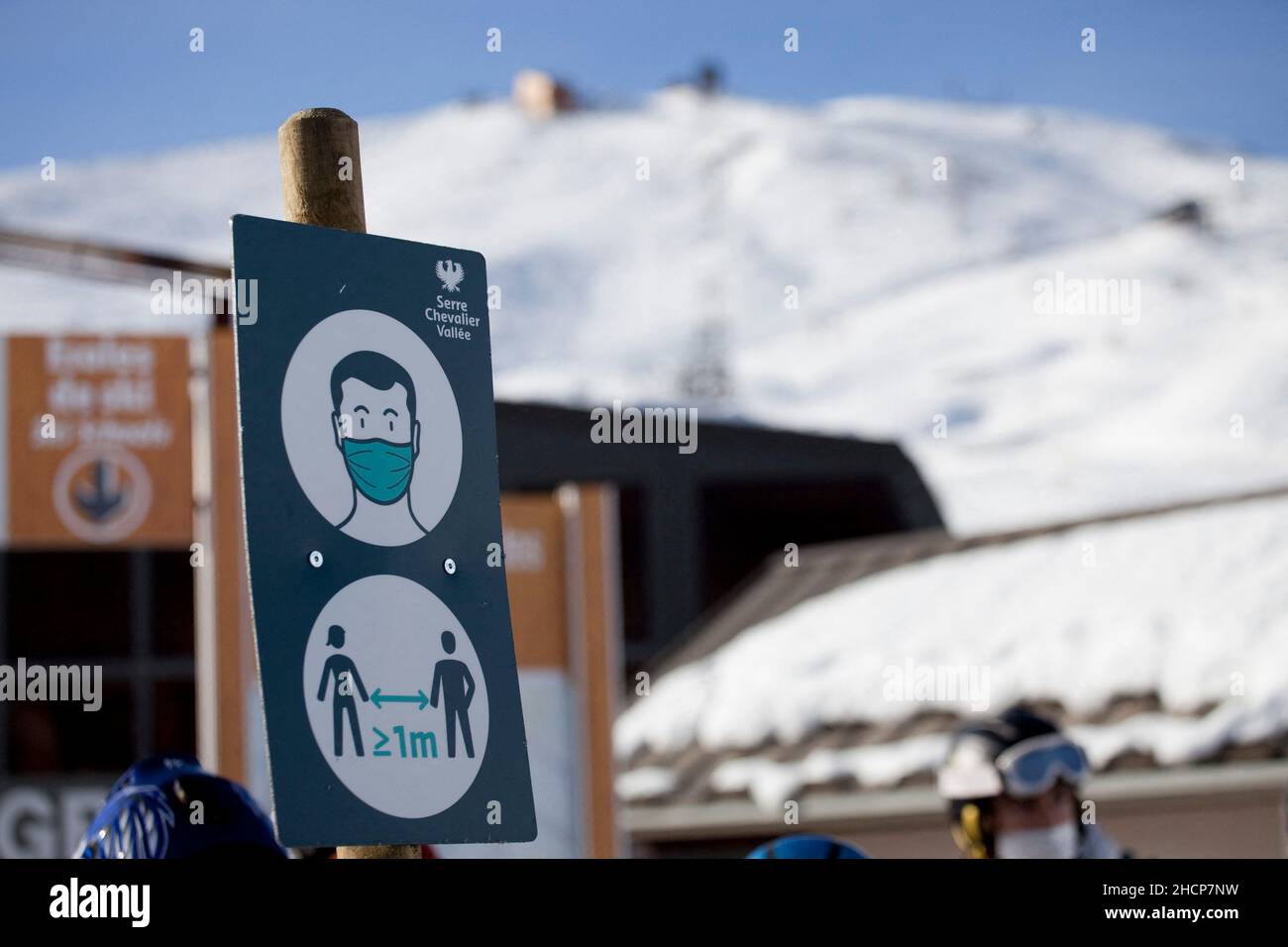 A sign indicates to people the obligation to wear the mask to take the ski lifts and to respect the social distentiation of 1 meter , Serre Chevalier, France on December 30, 2021. The outbreak of the Covid-19 epidemic continues in France with ever higher figures and records broken for the number of contaminations: more than 208,000 on Wednesday. New restrictions have been put in place in the ski resorts to counter the surge in coronavirus cases. The wearing of a mask is compulsory for all gatherings of more than 10 people on the public highway, in markets and in queues of all kinds. Photo by T Stock Photo