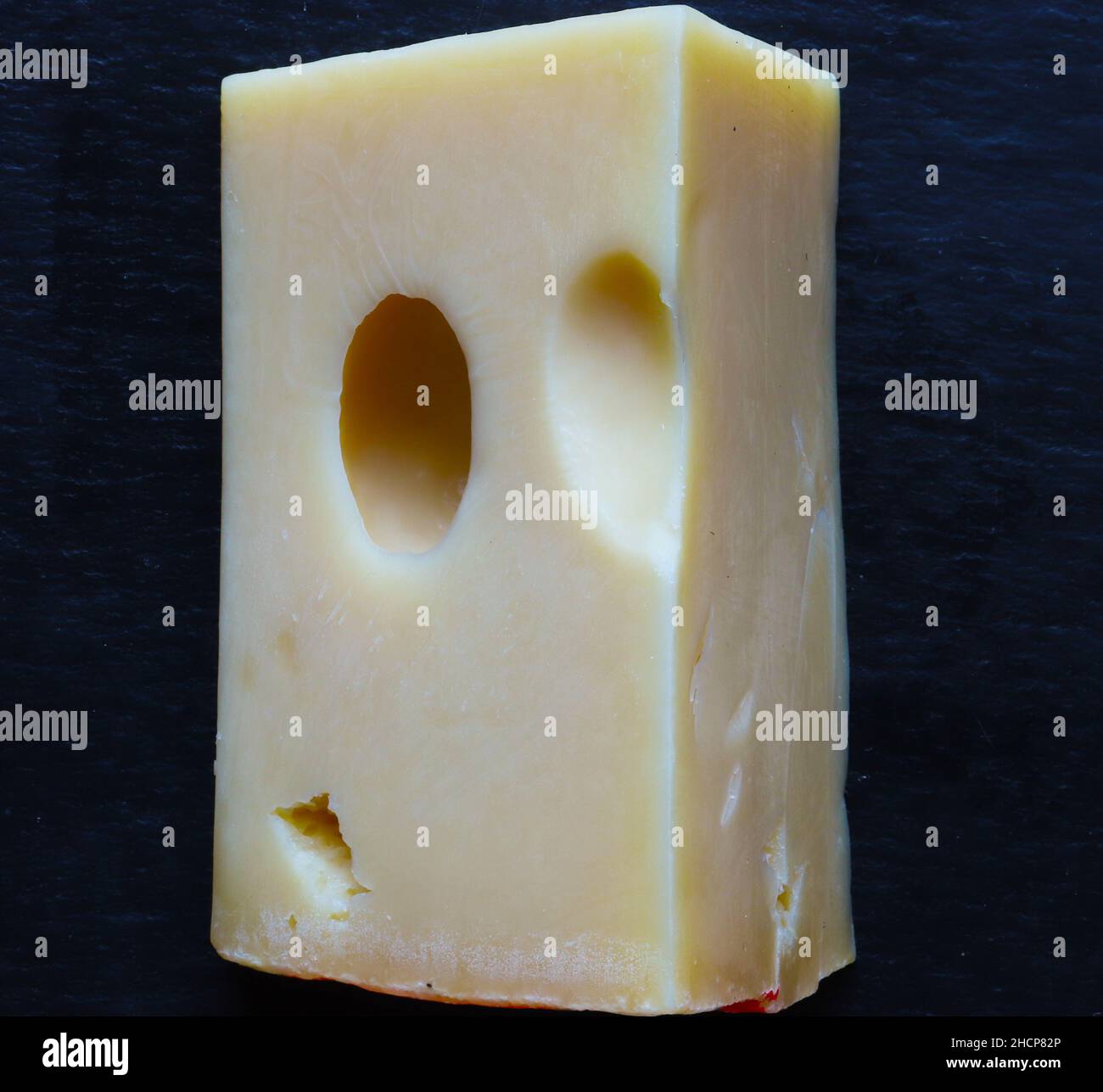 Photography of a piece of Emmental cheese on a slate for food