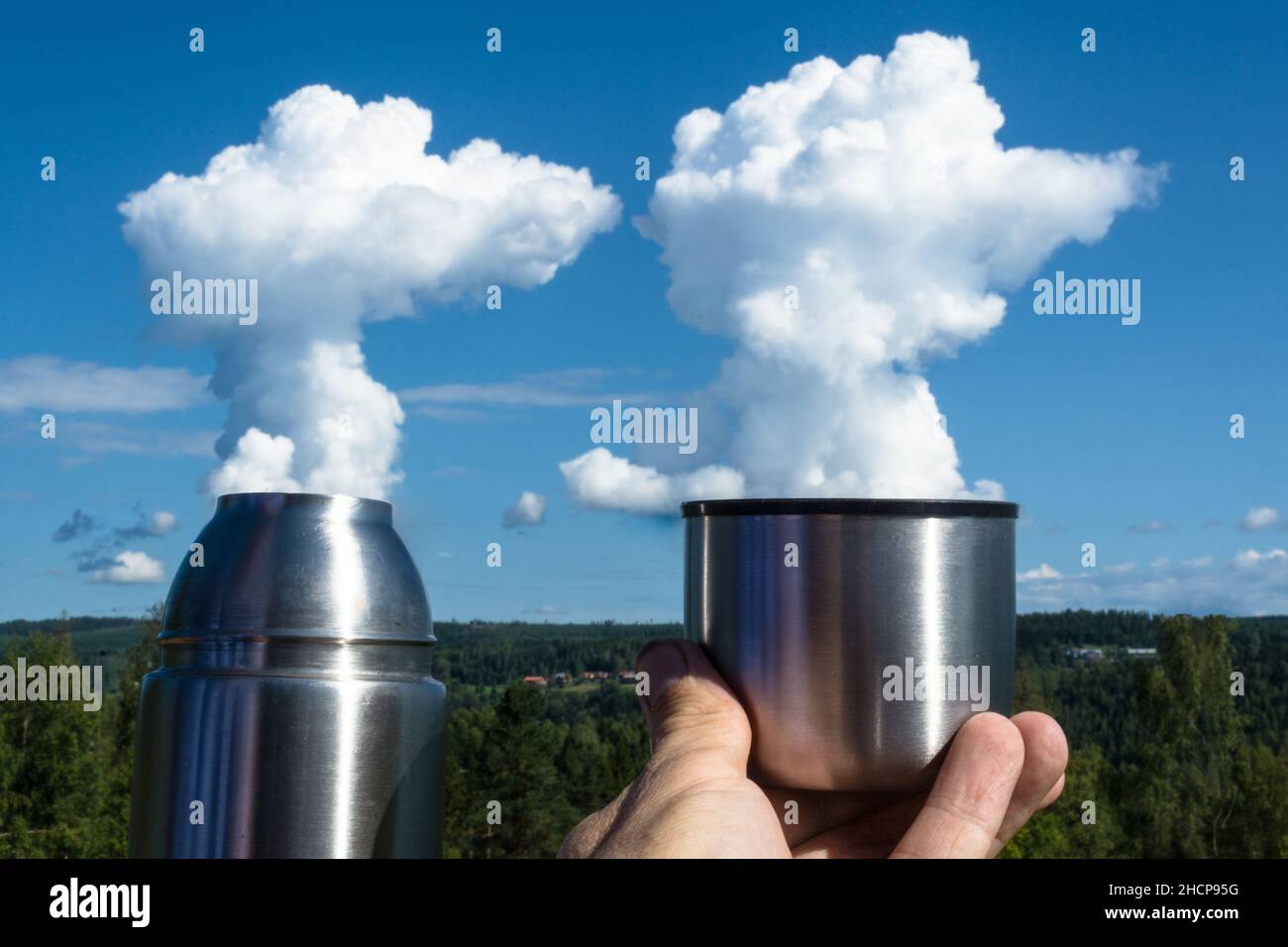 holding a thermoscan in a hand while clouds look like smoke Stock Photo