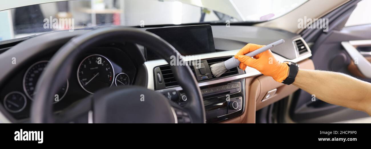 Manual cleaning of car interior with brush for hardtoreach places in