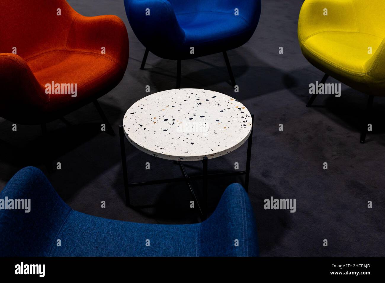 An empty meeting place during a pandemic. Colorful office chairs at the meeting place. lack of people. A place lit by atmospheric, artificial light. Stock Photo