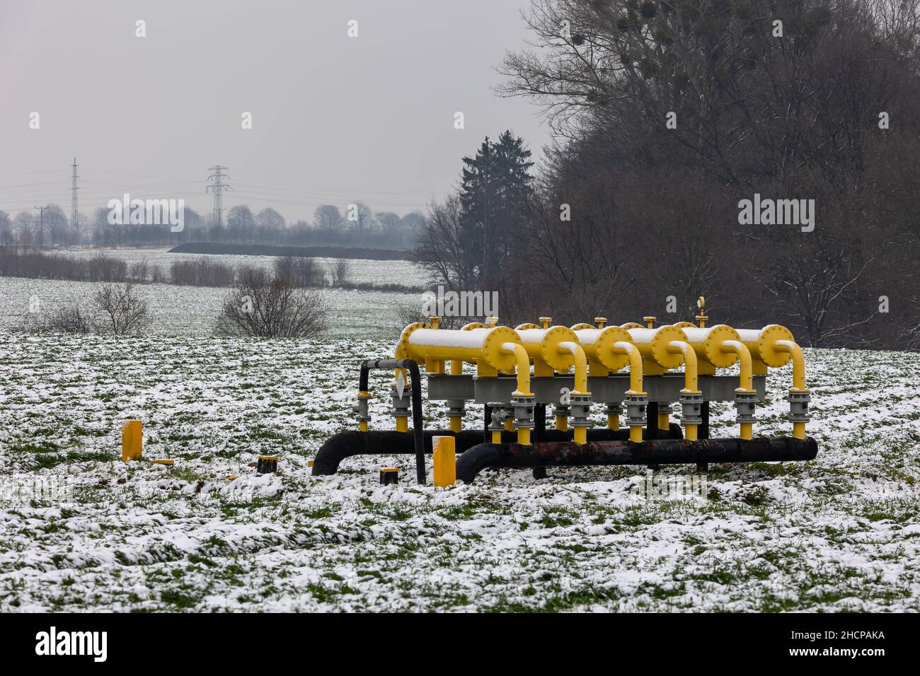 Yellow gas infrastructure elements sticking out of the ground. Winter photo of a snow-covered gas pipeline. High natural gas prices. The photo was tak Stock Photo