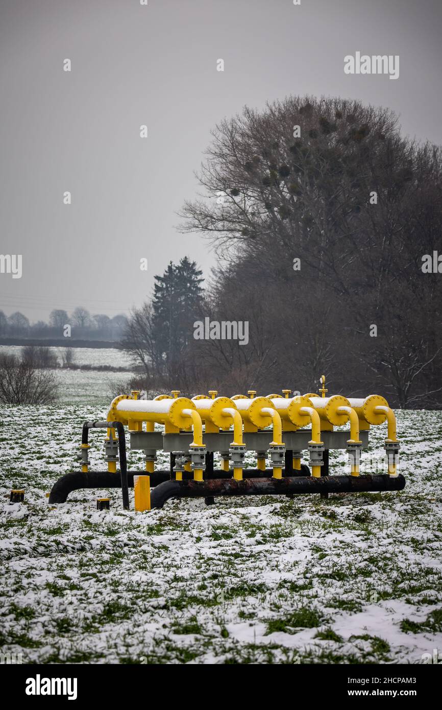 Yellow gas infrastructure elements sticking out of the ground. Winter photo of a snow-covered gas pipeline. High natural gas prices. The photo was tak Stock Photo