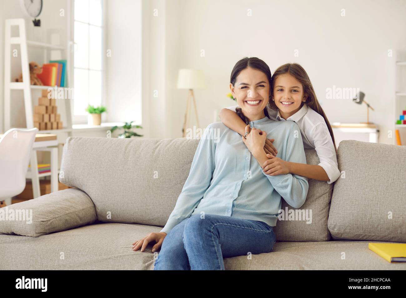 Portrait of happy young mom and teen daughter hug Stock Photo