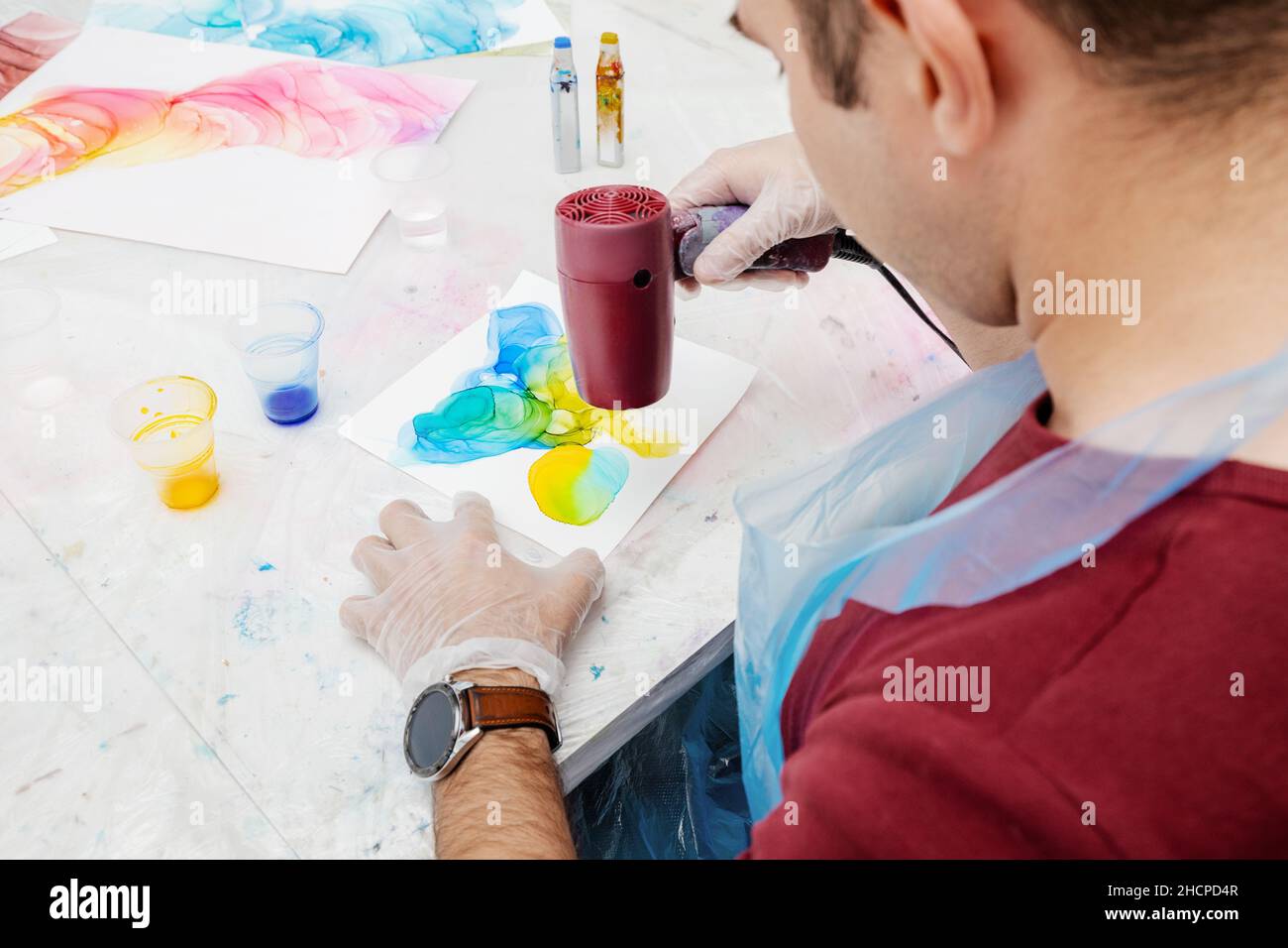 Person using a trending technique of drawing with alcoholic ink, when a