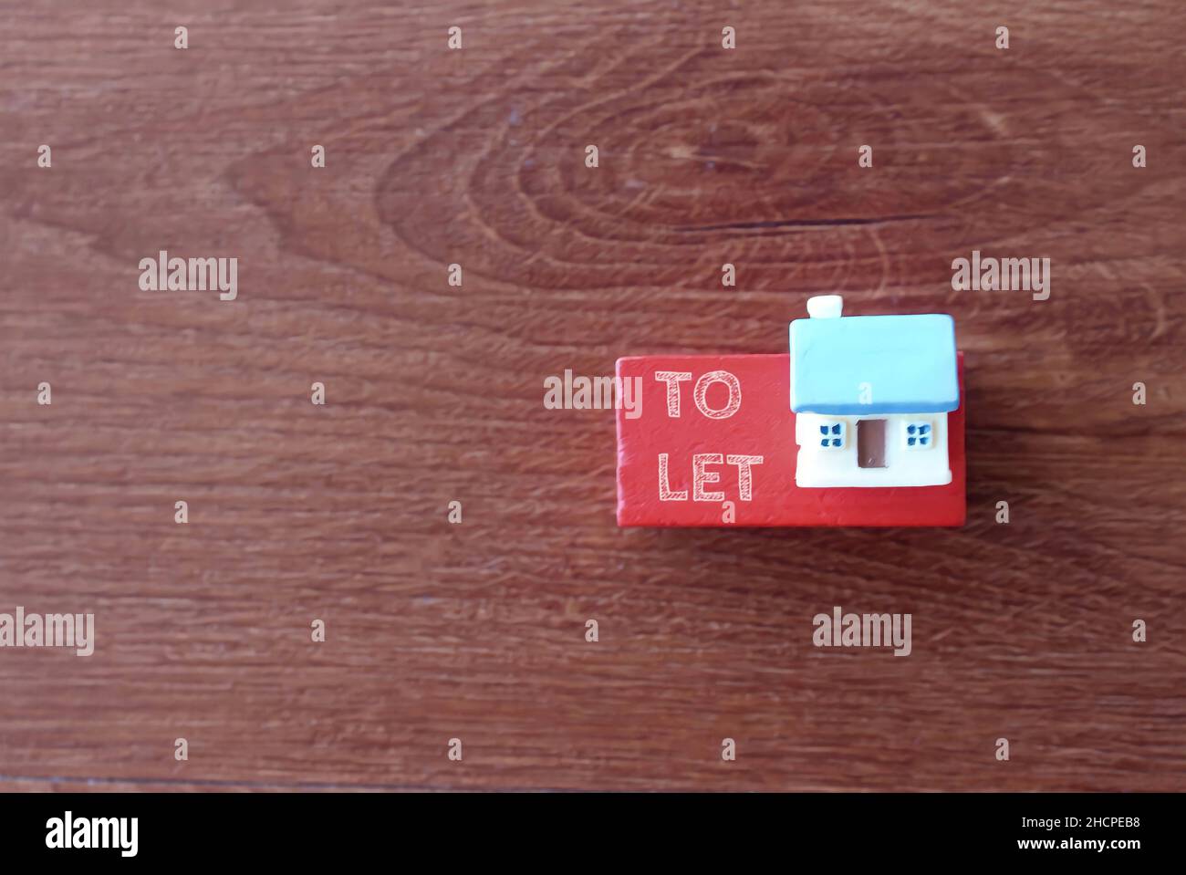 Selective focus image of miniature house and text TO LET. Real estate and property concept. Stock Photo