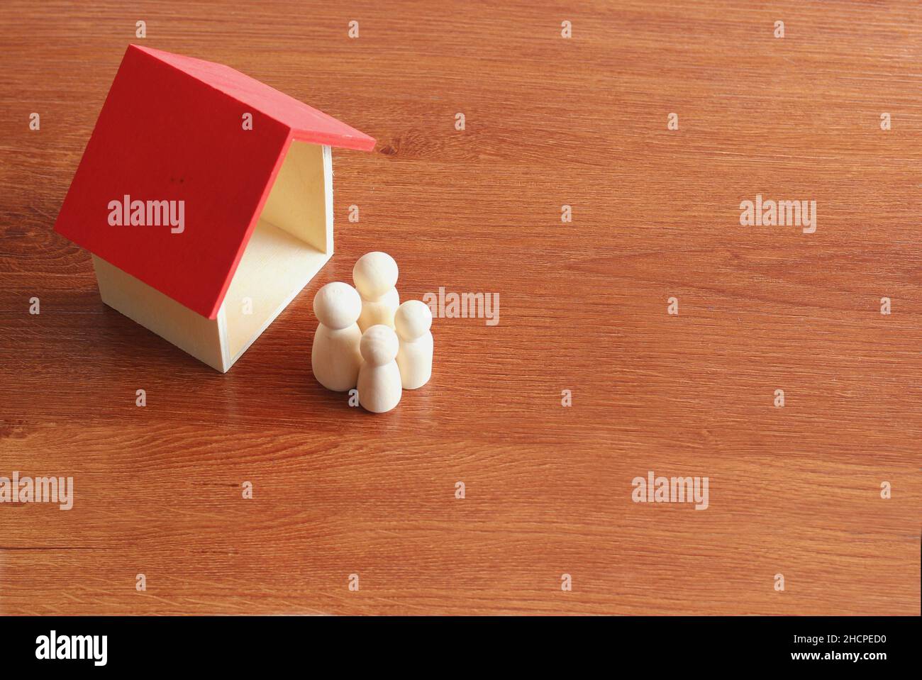 Family planning and property concept. Close up image of wooden toy house and dolls. Stock Photo