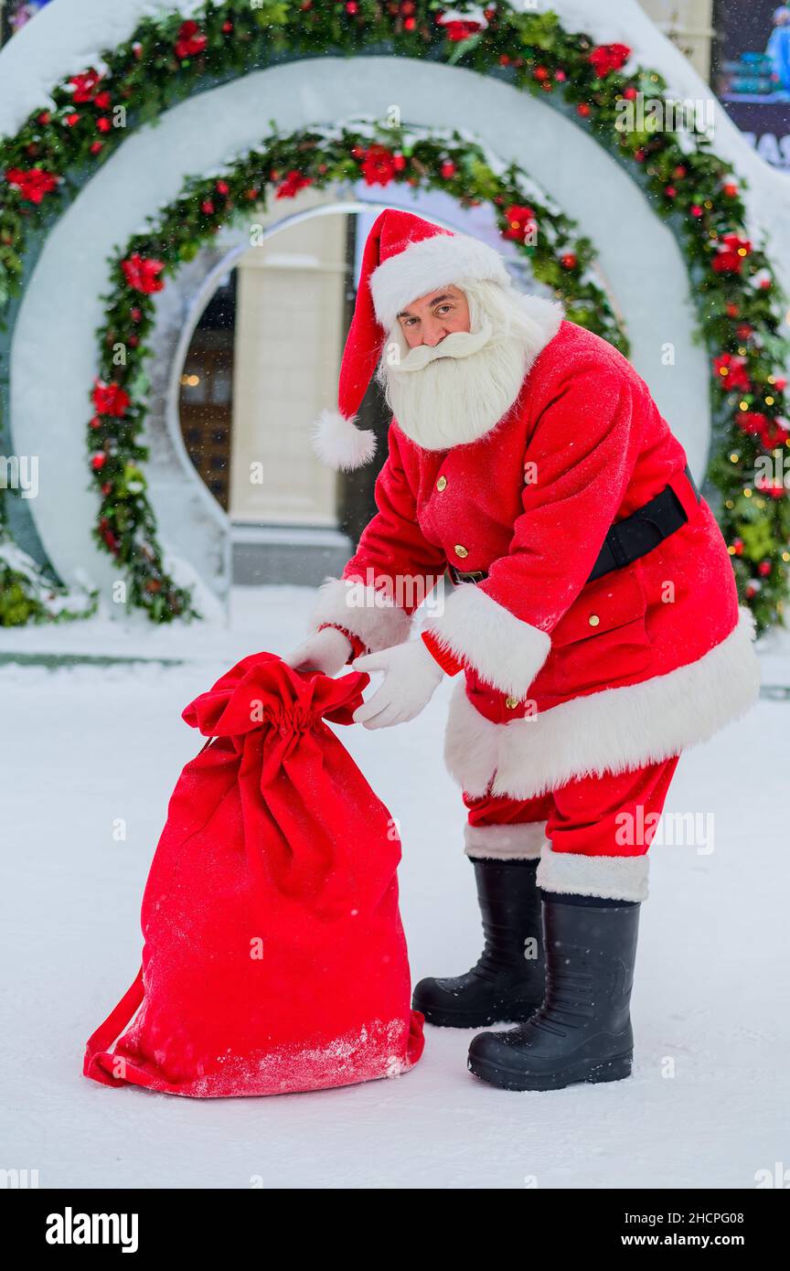 Santa Claus posing with a bag of gifts on the background of Christmas ...