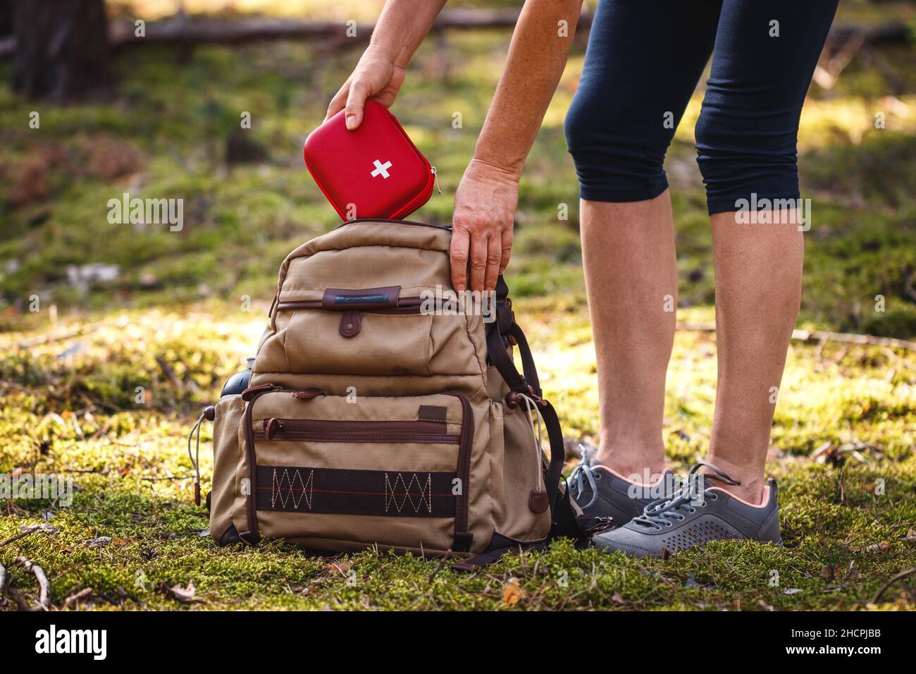 Hiker taking out first aid kit from backpack. Prepared for health problems during hiking. Travel insurance for all eventualities Stock Photo