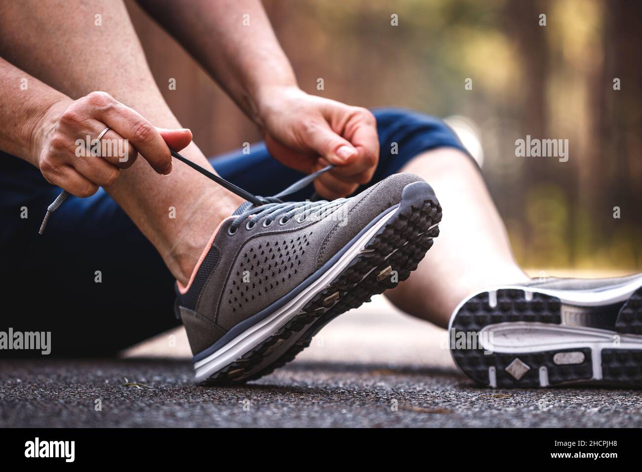 Woman tying sports shoe. Getting ready for jogging on road. Running for healthy and active
