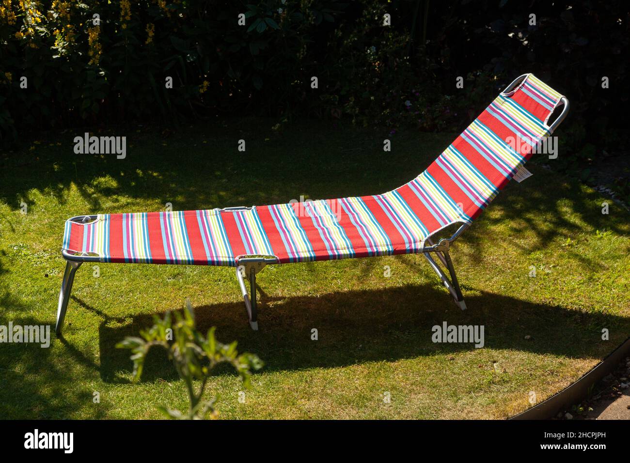 A folding sun lounger on grass in a back garden Stock Photo