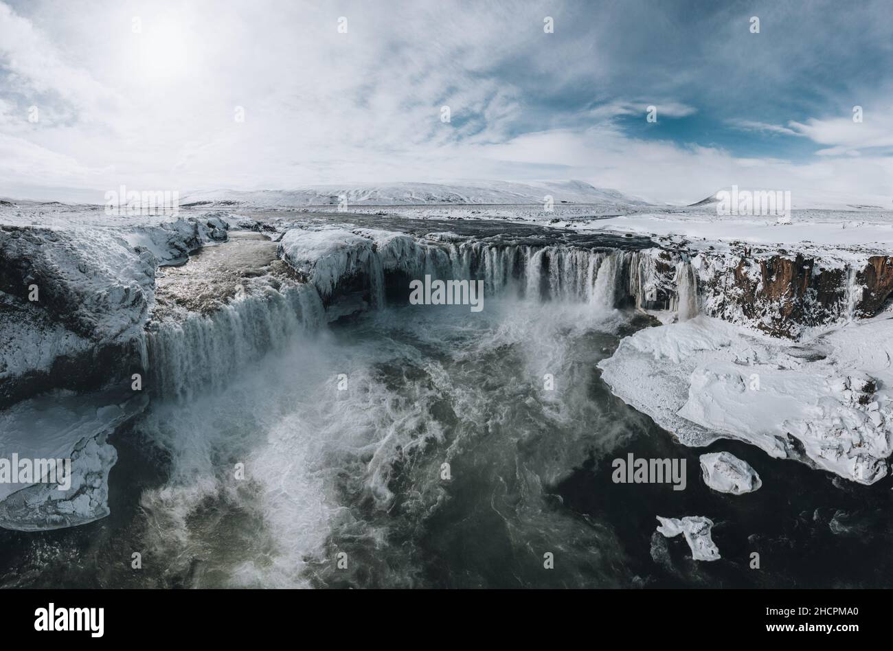 Drone shot of Godafoss waterfall, Iceland, taken from a high angle. Aerial view of the powerful cascade, river and snow covered rocks. Late autumn Stock Photo