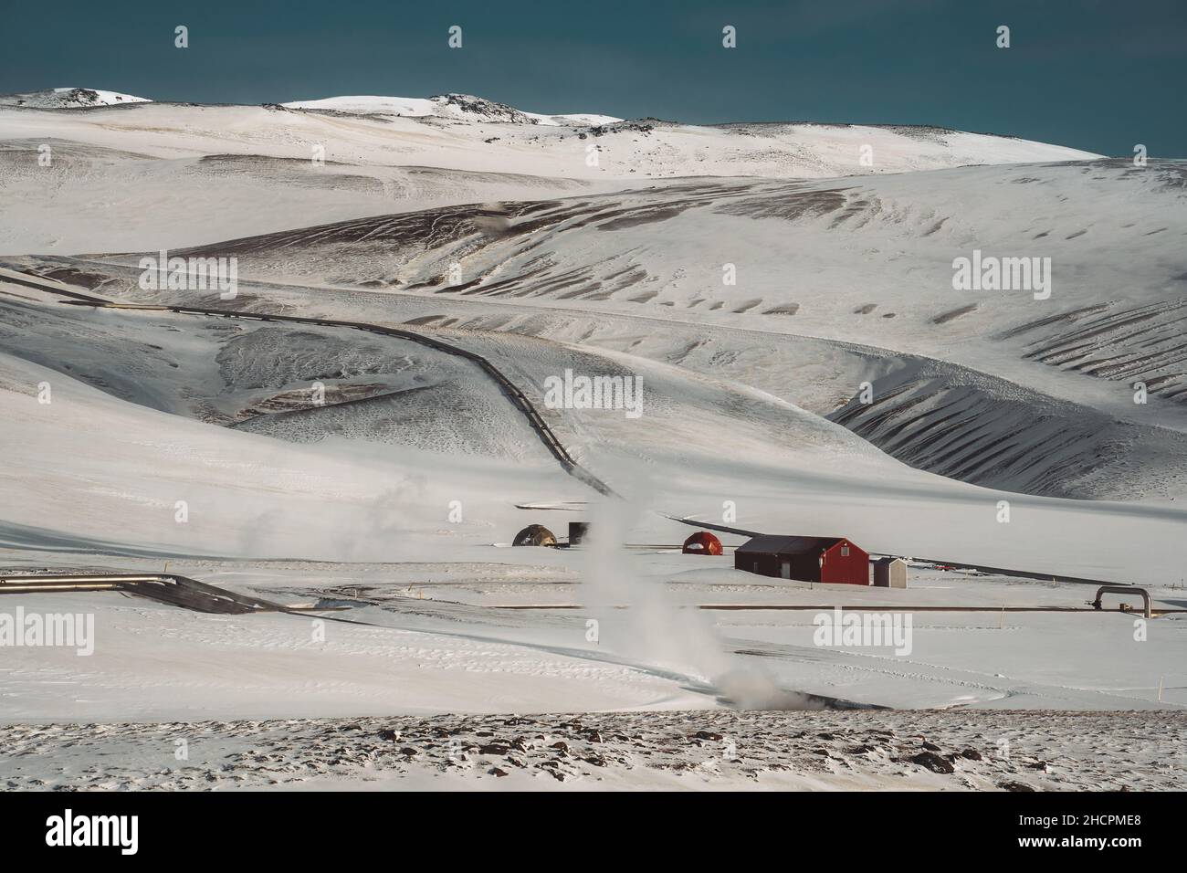 Icelandic landscape with geothermal power plant station kravla with igloo huts and pipes in the valley. Myvatn lake surroundings, Iceland Stock Photo