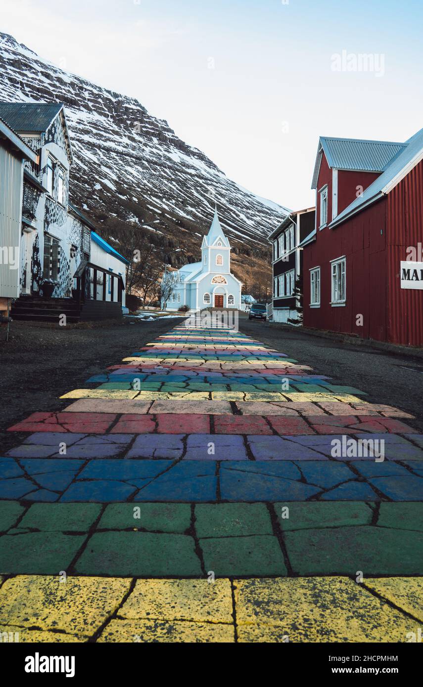 Rainbow stripes on pavement leading up to the Seydisfjordur Church in Iceland Stock Photo
