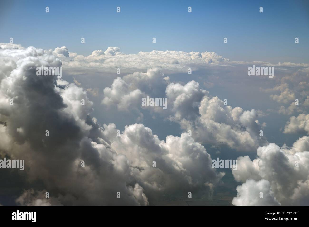 Aerial view from airplane window of white puffy clouds on bright sunny ...