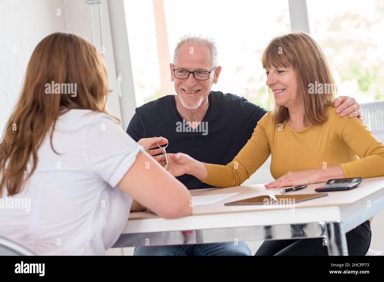 Real estate agent giving house keys to senior couple Stock Photo - Alamy