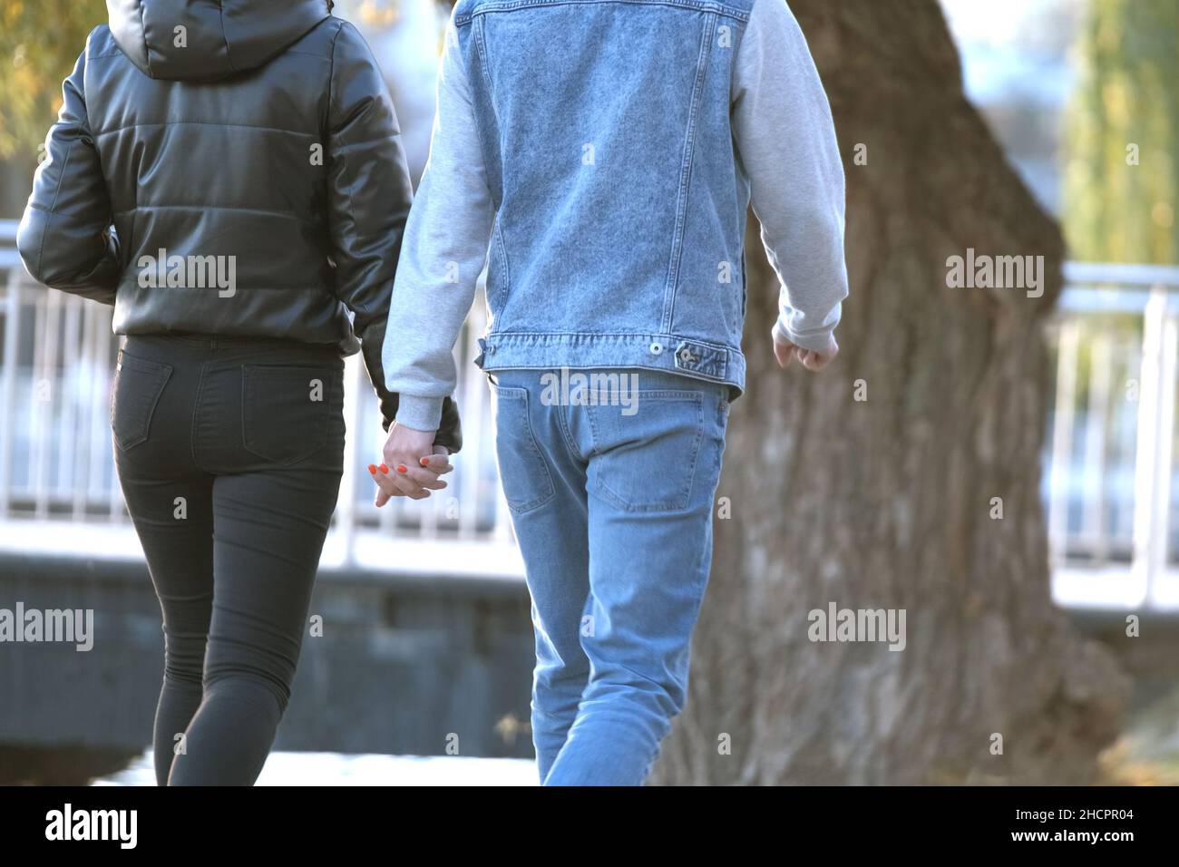 Back view of young couple walking on city street enjoying time together ...