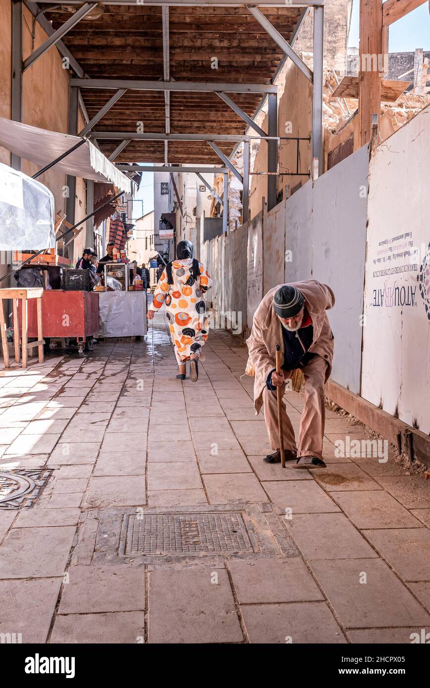 Senior man walking on street with abnormal curvature of his upper spine