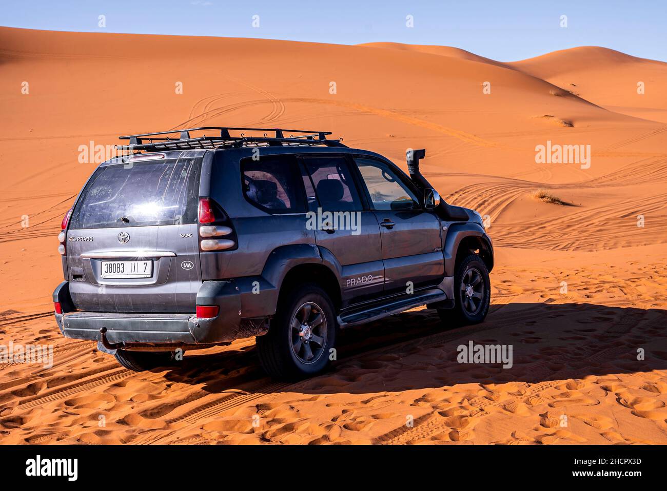 Black land cruiser prado parked in sand dunes on sunny summer day Stock Photo