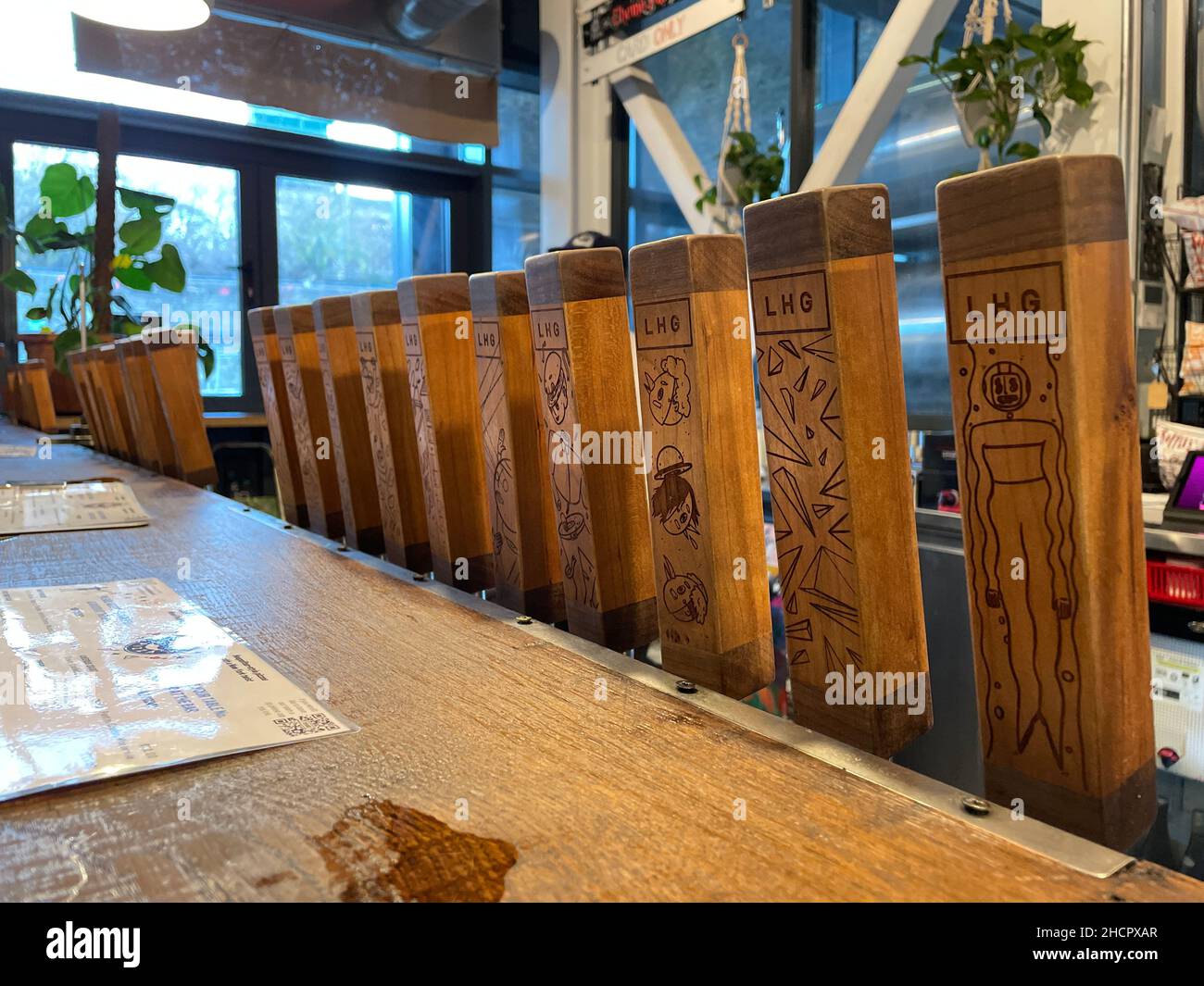 A row of wooden beer pump handles for dispensing ale at the 'left handed giant' brew pub in Bristol.UK Stock Photo
