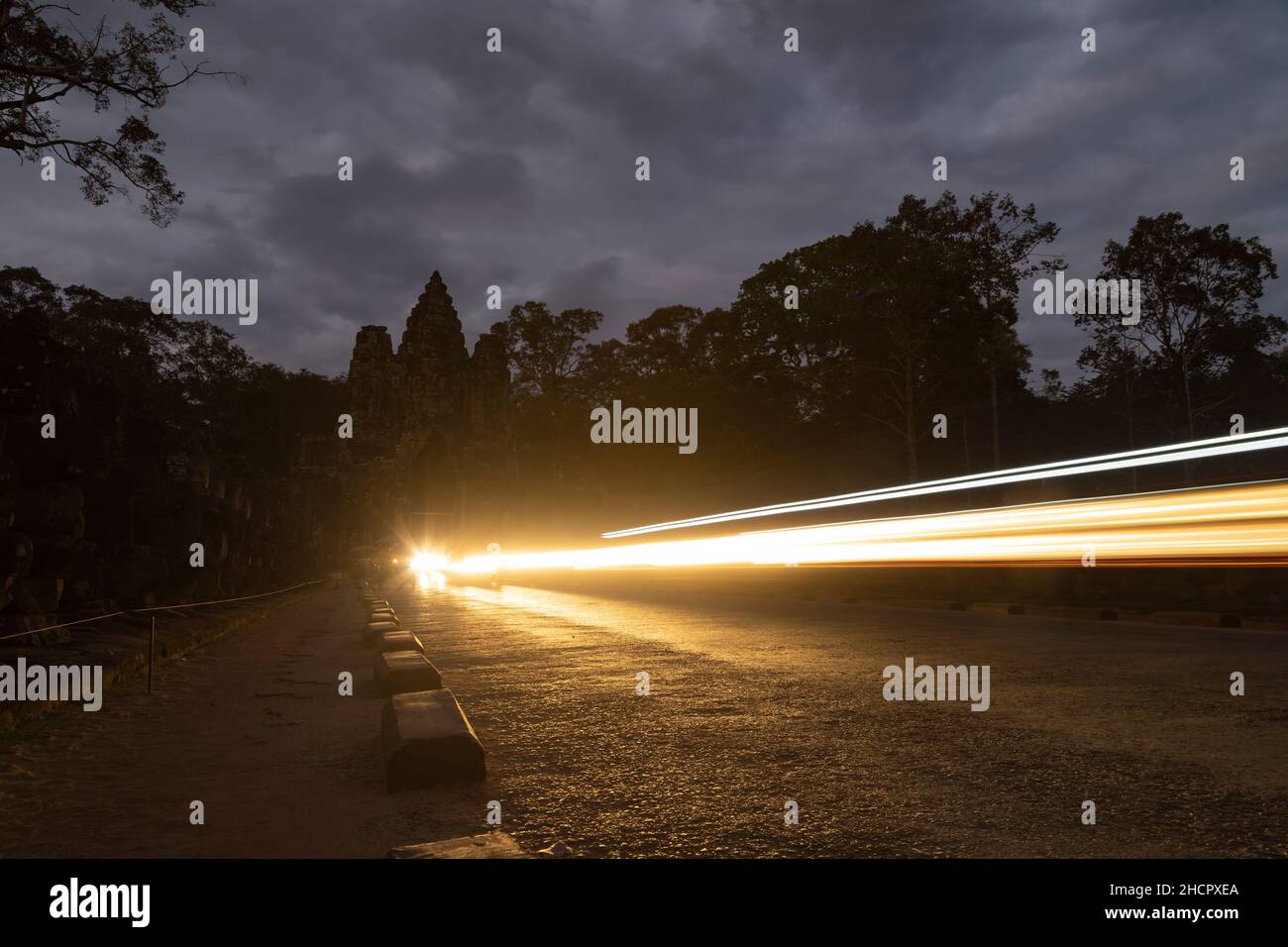 Lights and night traffic passing through the Tonle Om Gate, the Southern Gate that gives access to the larger area of Angkor Archaeological Park, Camb Stock Photo