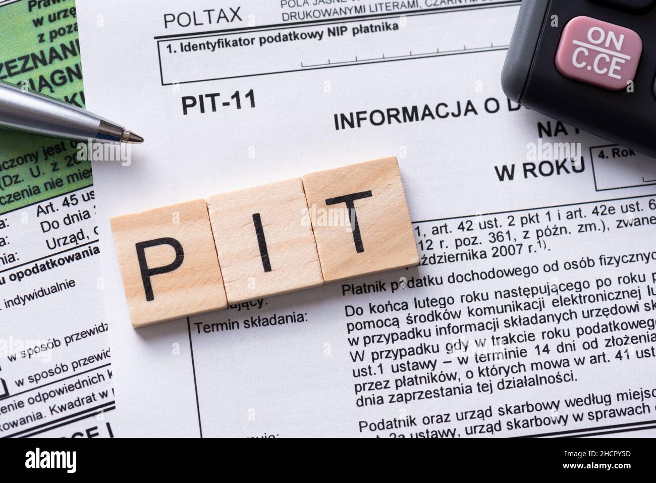 Tax concept with polish tax forms and PIT word from tiles, means