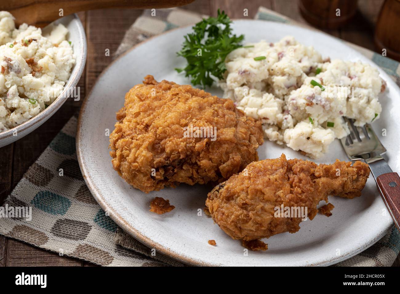 Crispy fried chicken leg and thigh dinner with mashed potatoes on a