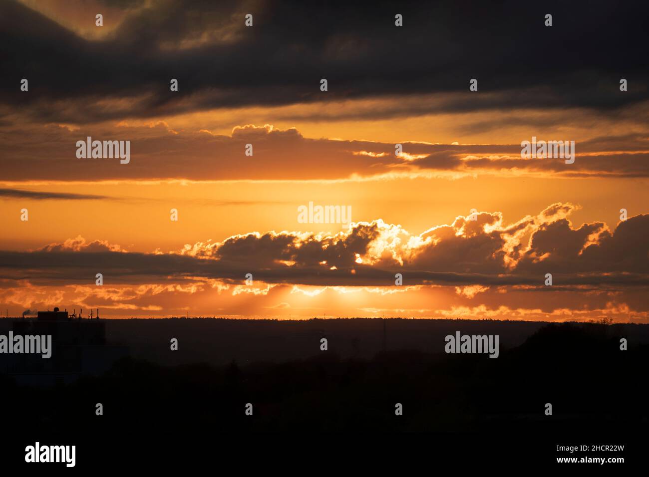 Sunset over a silhouetted landscape. Stock Photo