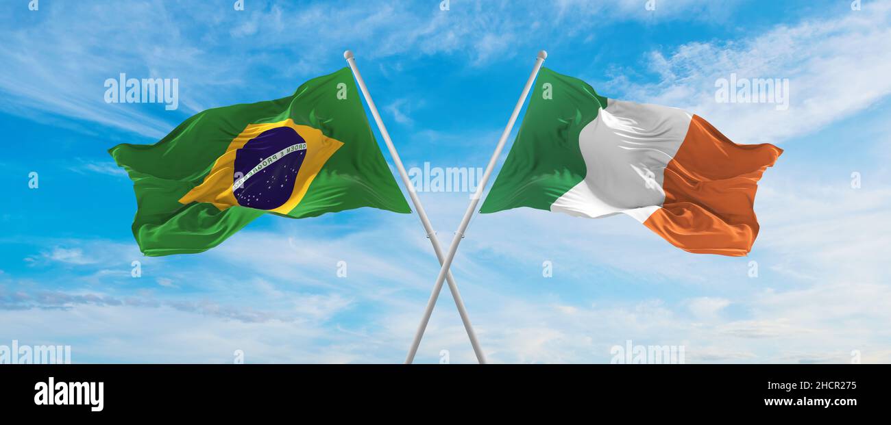 crossed national flags of Brazil and Ireland flag waving in the wind at ...