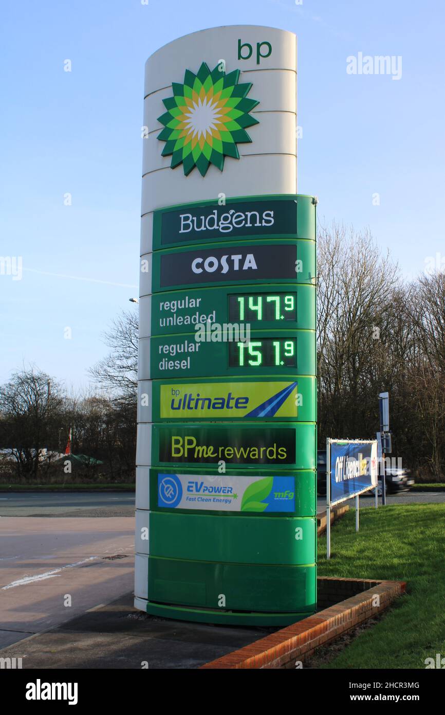 BP sign with fuel prices, electric charging service,  Budgens and Costa Stock Photo