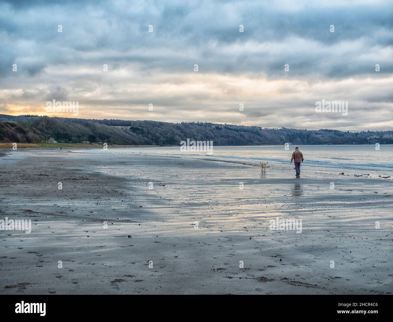 Walking the dog at Croy beach South Ayrshire in winter Stock Photo