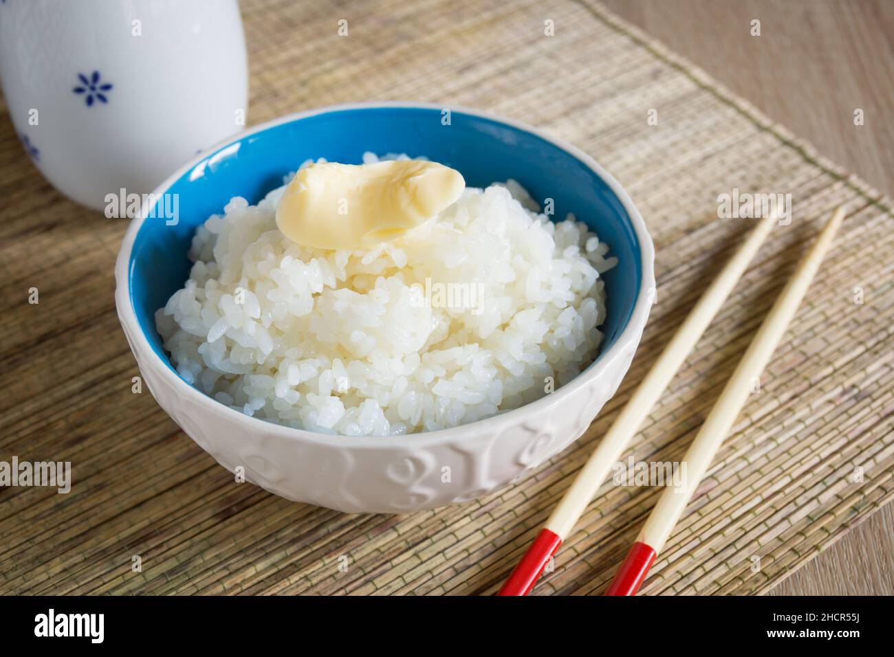 Japanese Uruchimai rice with a knob of butter in a pretty ceramic bowl Stock Photo