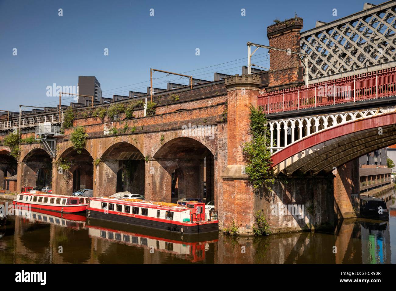 UK, England, Manchester, Castlefield, City Centre Cruise narrowboats moored on Bridgewater Canal below Metrolink Railway Viaduct Stock Photo