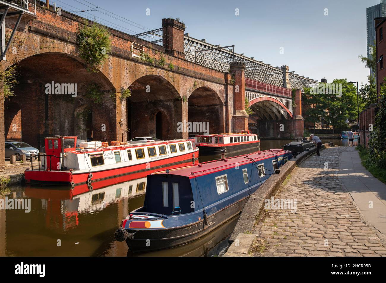 UK, England, Manchester, Castlefield, narrowboats moored on Bridgewater Canal below Metrolink Railway Viaduct Stock Photo