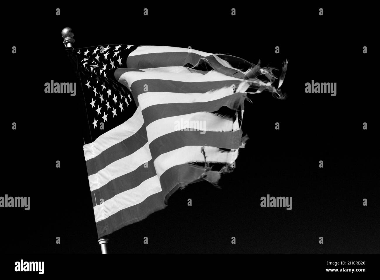 A tattered American flag flies in the wind in Taos, New Mexico Stock