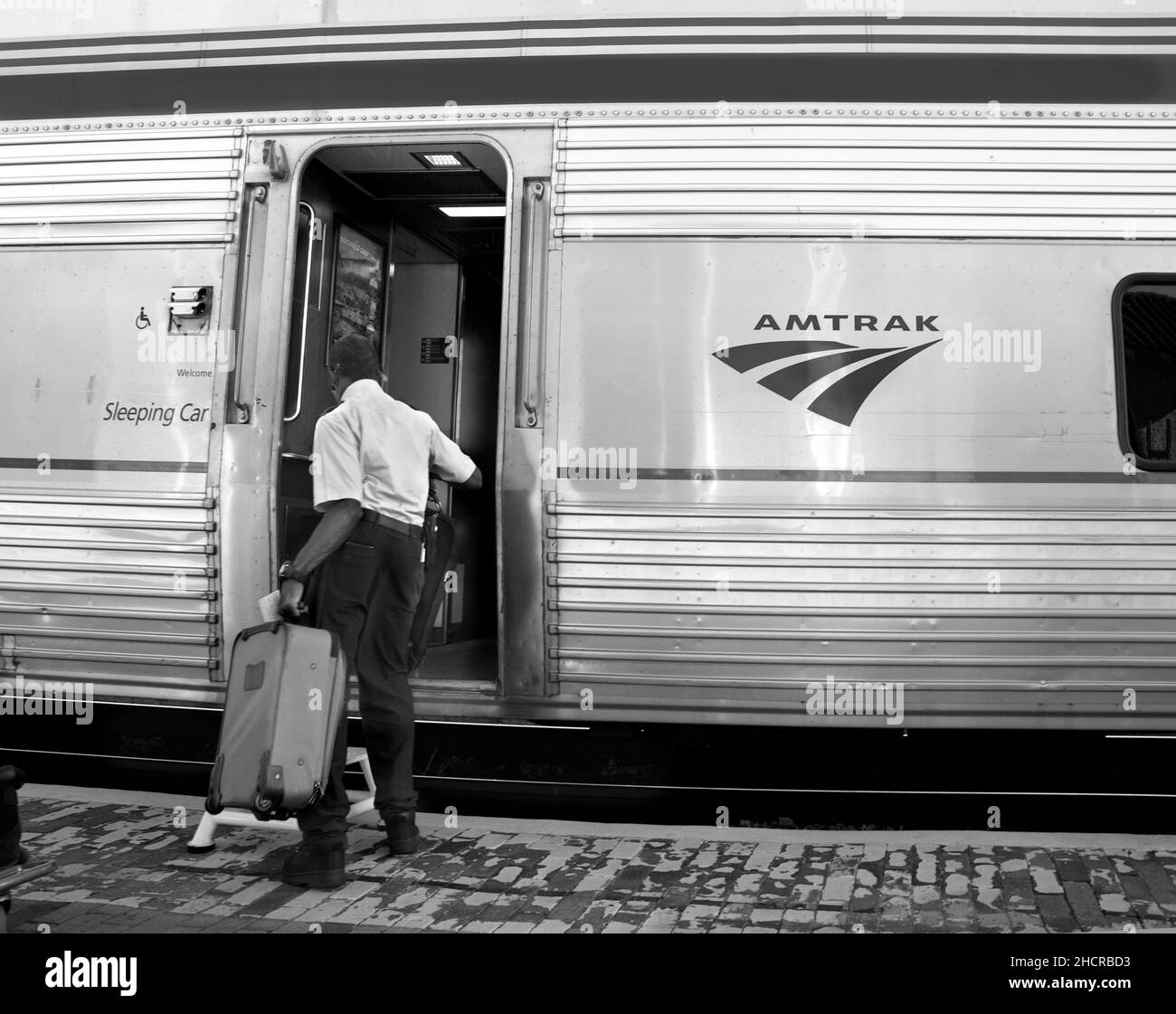 An Amtrak train porter helps load a boarding passenger's luggage at the train station in Lamy, New Mexico. Stock Photo