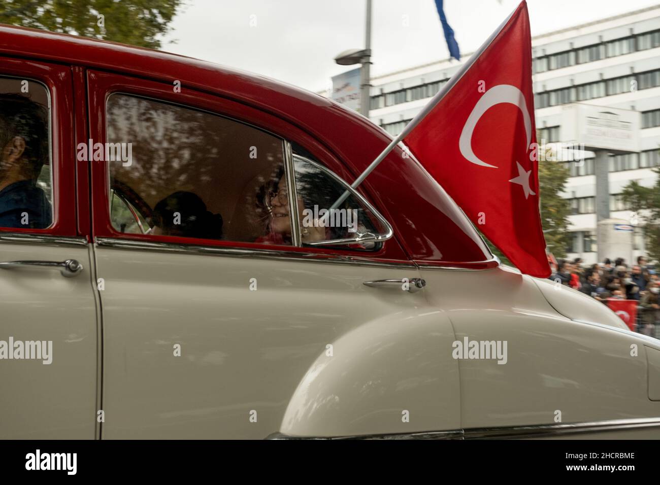 Istanbul, Turkey - October 29, 2021: A woman holding turkish flag in window of old car for october 29 republic day. Editorial Shot in Istanbul Turkey. Stock Photo