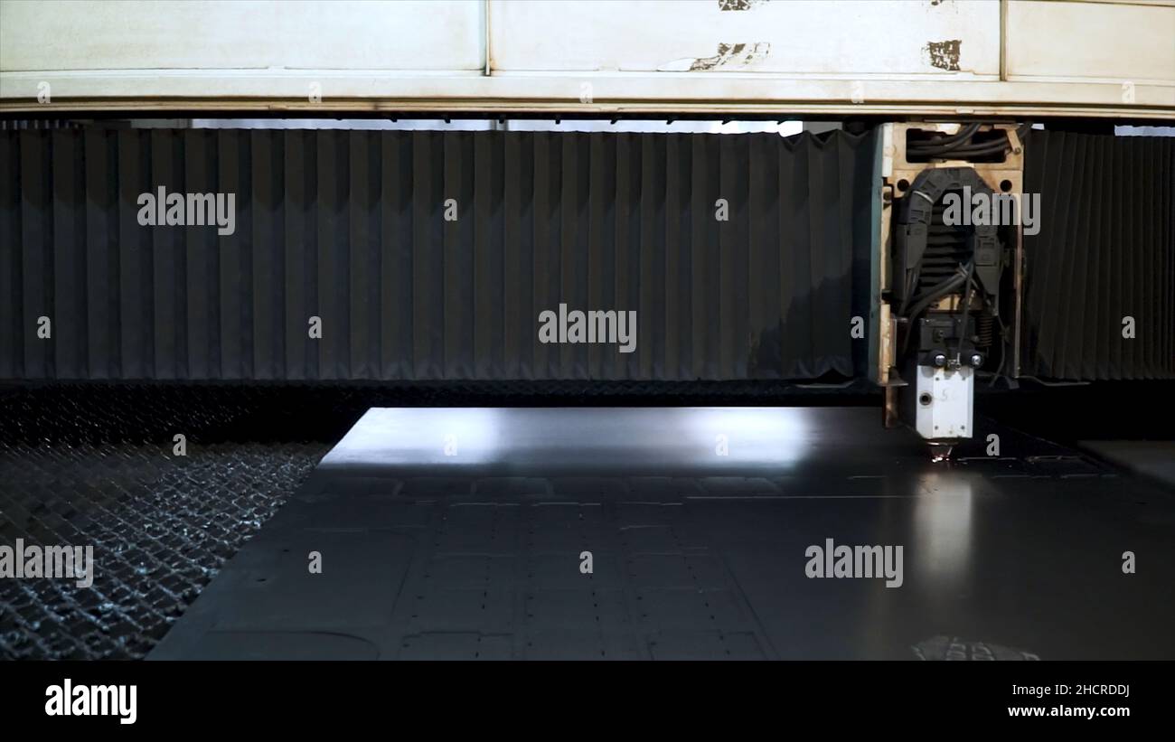 Cut sheet metal at workshop. Clip. Fiber laser machines for metal cutting close-up. Modern tool in heavy industry. Dangerous job. High precision manuf Stock Photo