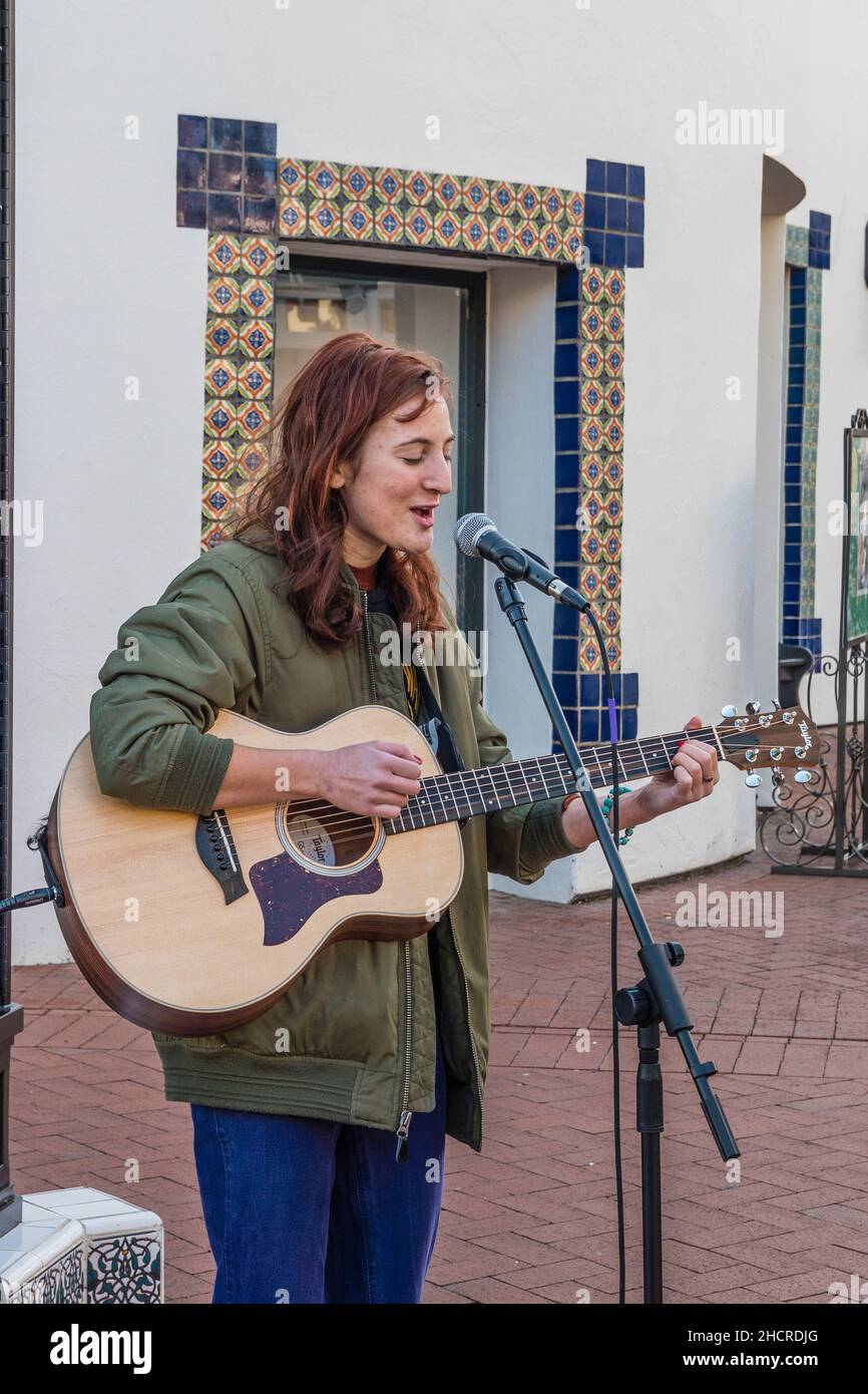 A female folk musician plays guitar outside Stock Photo