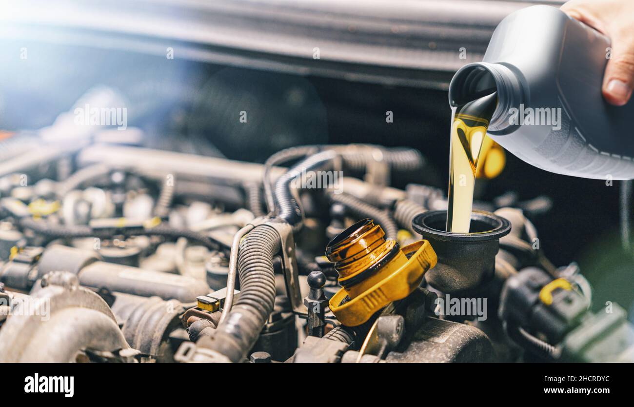 Pouring oil to car engine. Fresh motor oil poured during an oil change