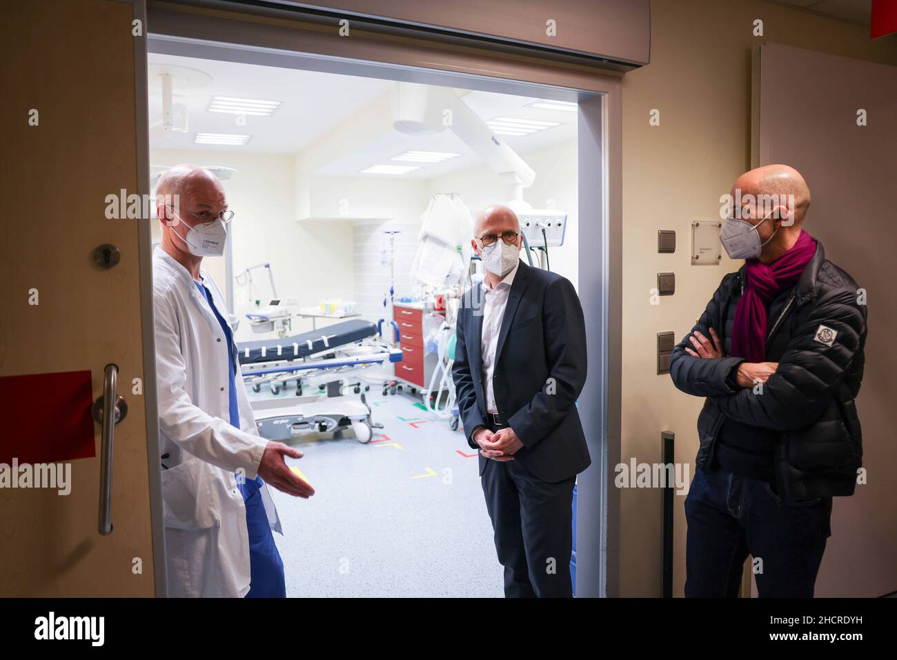 Hamburg, Germany. 31st Dec, 2021. Peter Tschentscher (SPD, M), First Mayor of Hamburg, Dirk Pabst (l), Senior Physician Central Emergency Department at Asklepios Klinikum Harburg, and Joachim Gemmel, Managing Director of Asklepios Kliniken Hamburg, stand in the entrance to a shock room in the emergency department during a visit to Asklepios Klinikum Harburg as part of his New Year's Eve tour. Credit: Christian Charisius/dpa/Alamy Live News Stock Photo