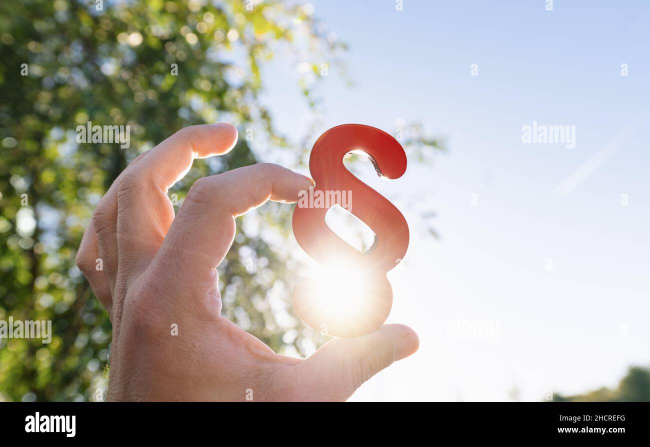 Close-up of a person's hand holding red paragraph symbol Stock Photo