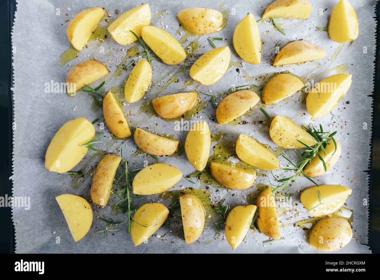 raw potato wedges on baking tray Stock Photo