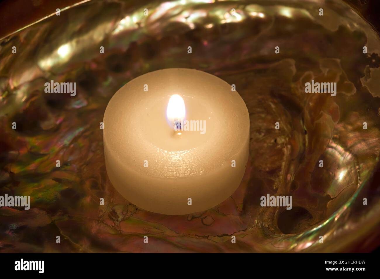 Abalone Seashell with a lit candle. Stock Image. Stock Photo